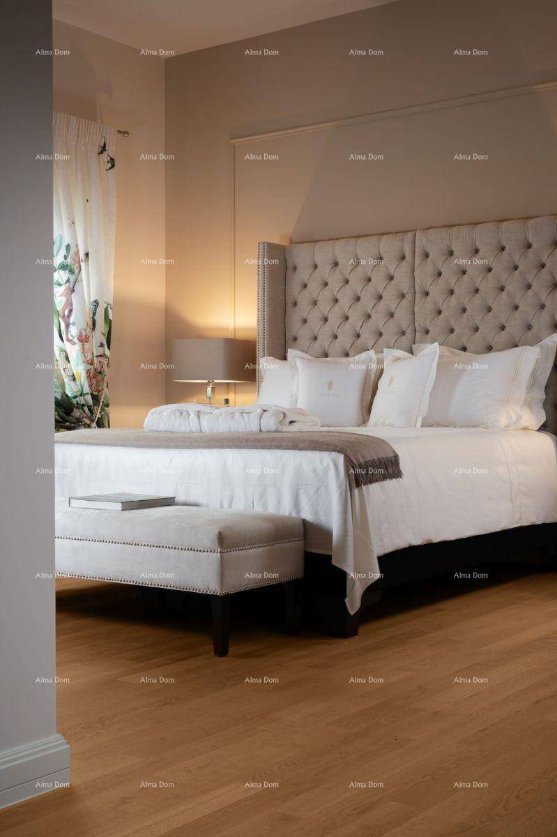 Helles Schlafzimmer mit großem Bett, gepolstertem Kopfteil und Holzboden.