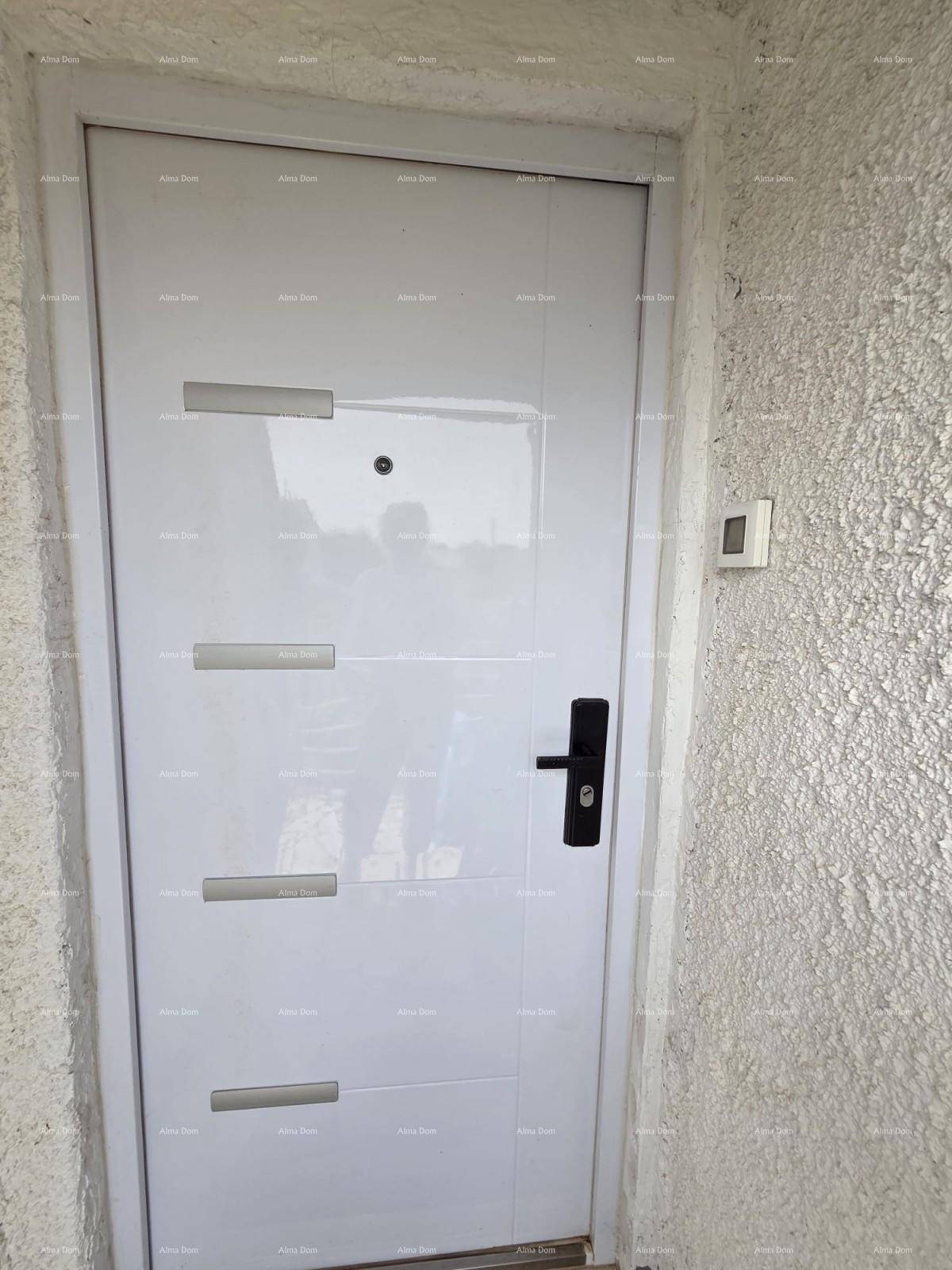 Nahaufnahme einer modernen weißen Eingangstür mit dunklem Griff und strukturierter Wand.
