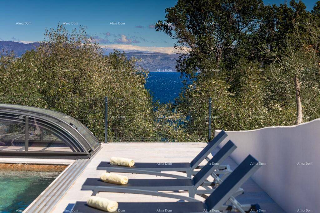 Poolbereich mit Liegestühlen und Panoramablick auf das Meer und die Küstenlandschaft.