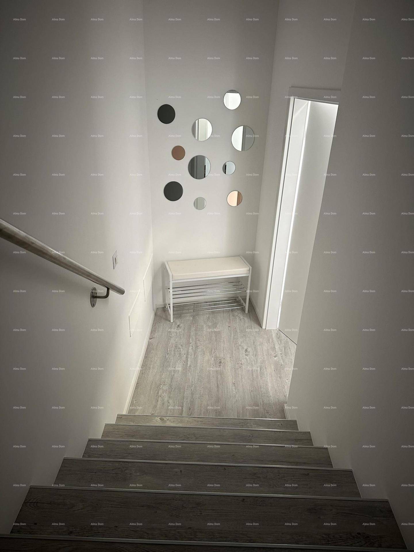 Treppenabgang mit dekorativen Spiegeln an der Wand und einer kleinen Sitzbank im Flurbereich.