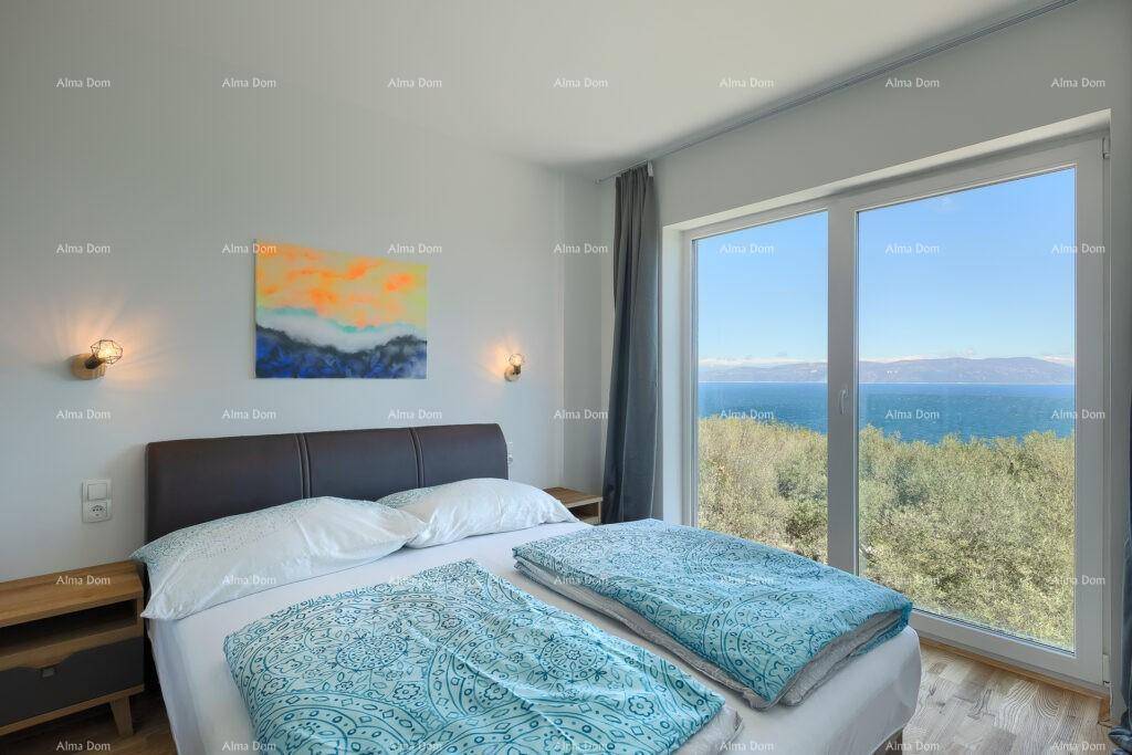 Schlafzimmer mit Doppelbett, großen Fenstern und direktem Meerblick.