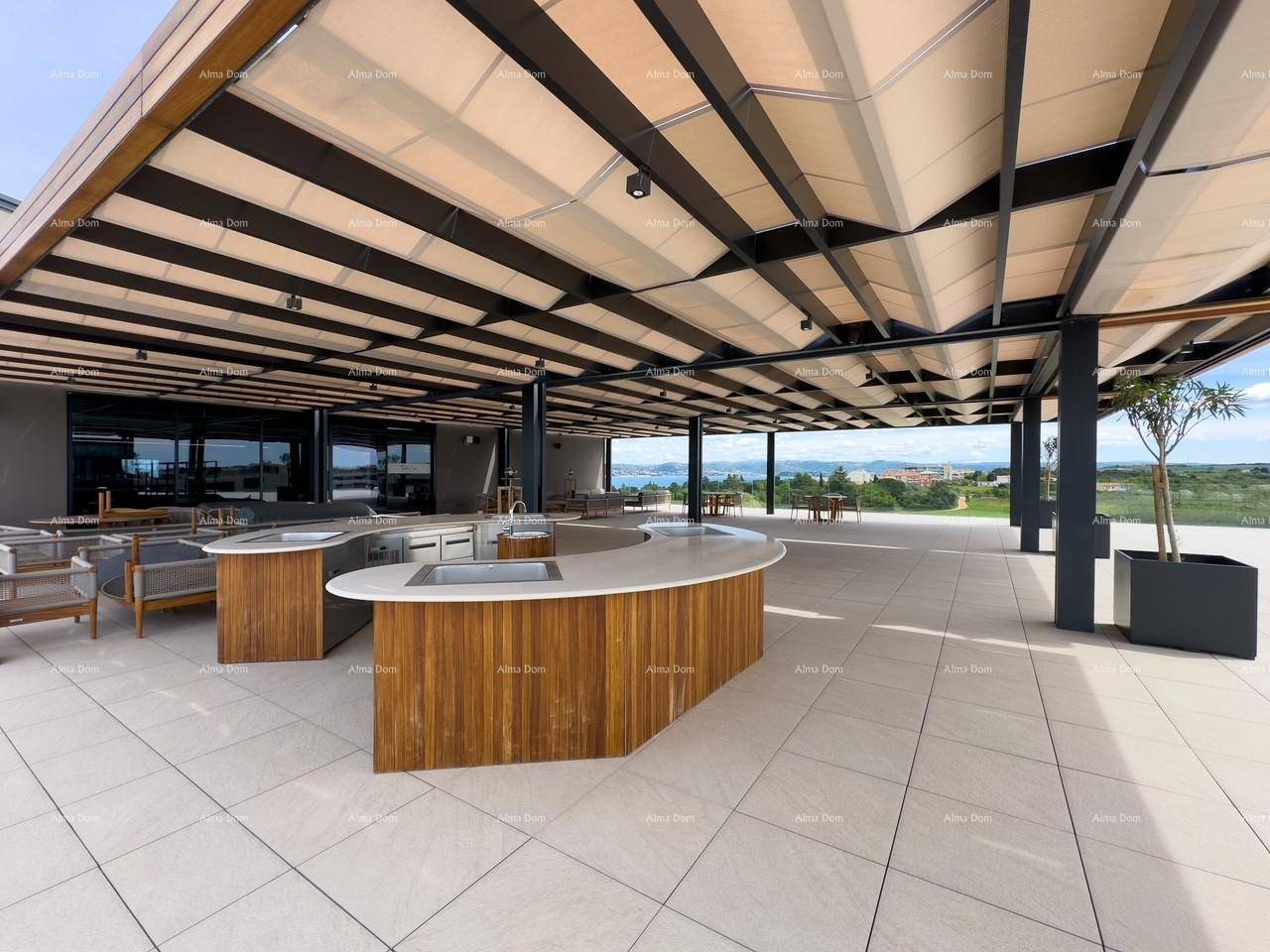 Großzügige Außenterrasse mit verschiedenen Sitzbereichen und einer stilvollen Außenküche unter einer Pergola mit Meerblick.