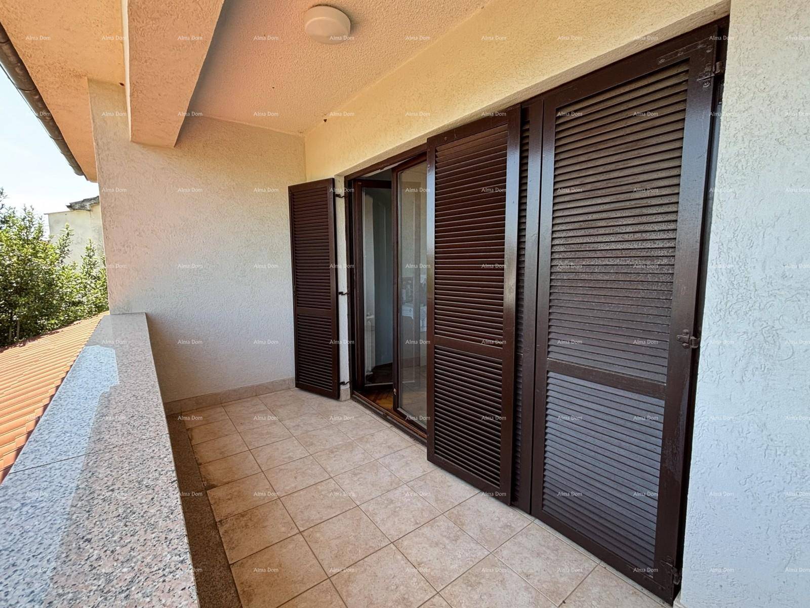 Balkon mit Fliesenboden und braunen Fensterläden, bietet einen sonnigen Außenbereich.