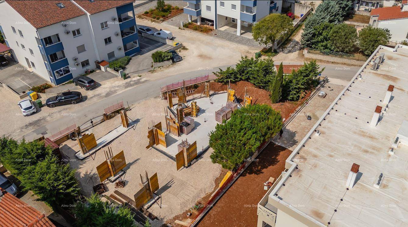Vogelperspektive auf eine Baustelle mit Fundamenten und Schalungen, umgeben von weiteren Wohngebäuden.