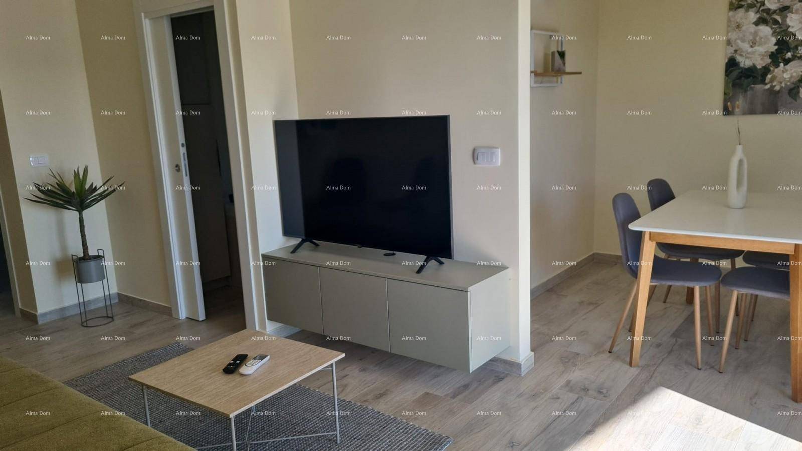 Offener Wohn- und Essbereich mit Sofa, Fernseher und modernem Esstisch.