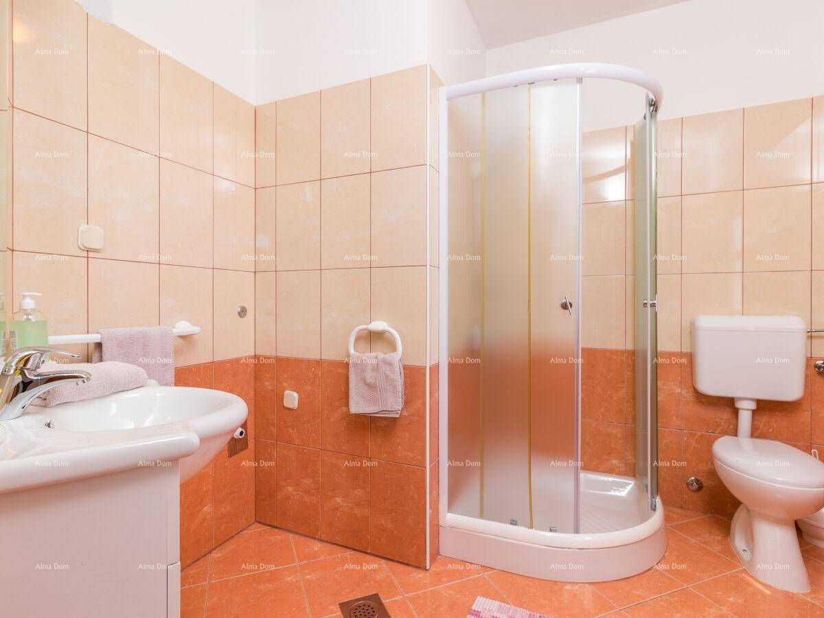 Badezimmer mit orangefarbenen Fliesen, Duschkabine und WC.
