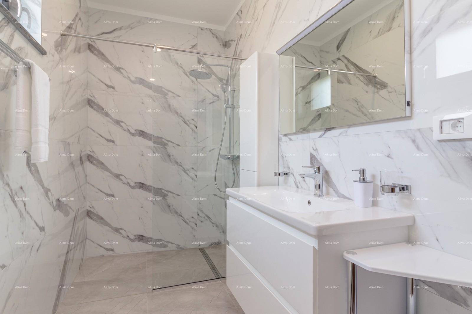 Helles Badezimmer mit Marmorfliesen, begehbarer Dusche und Spiegelschrank.