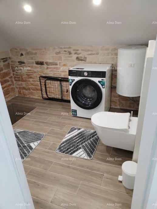 Praktischer Hauswirtschaftsraum mit Waschmaschine, Toilette und Fliesenboden, bietet zusätzlichen Komfort.