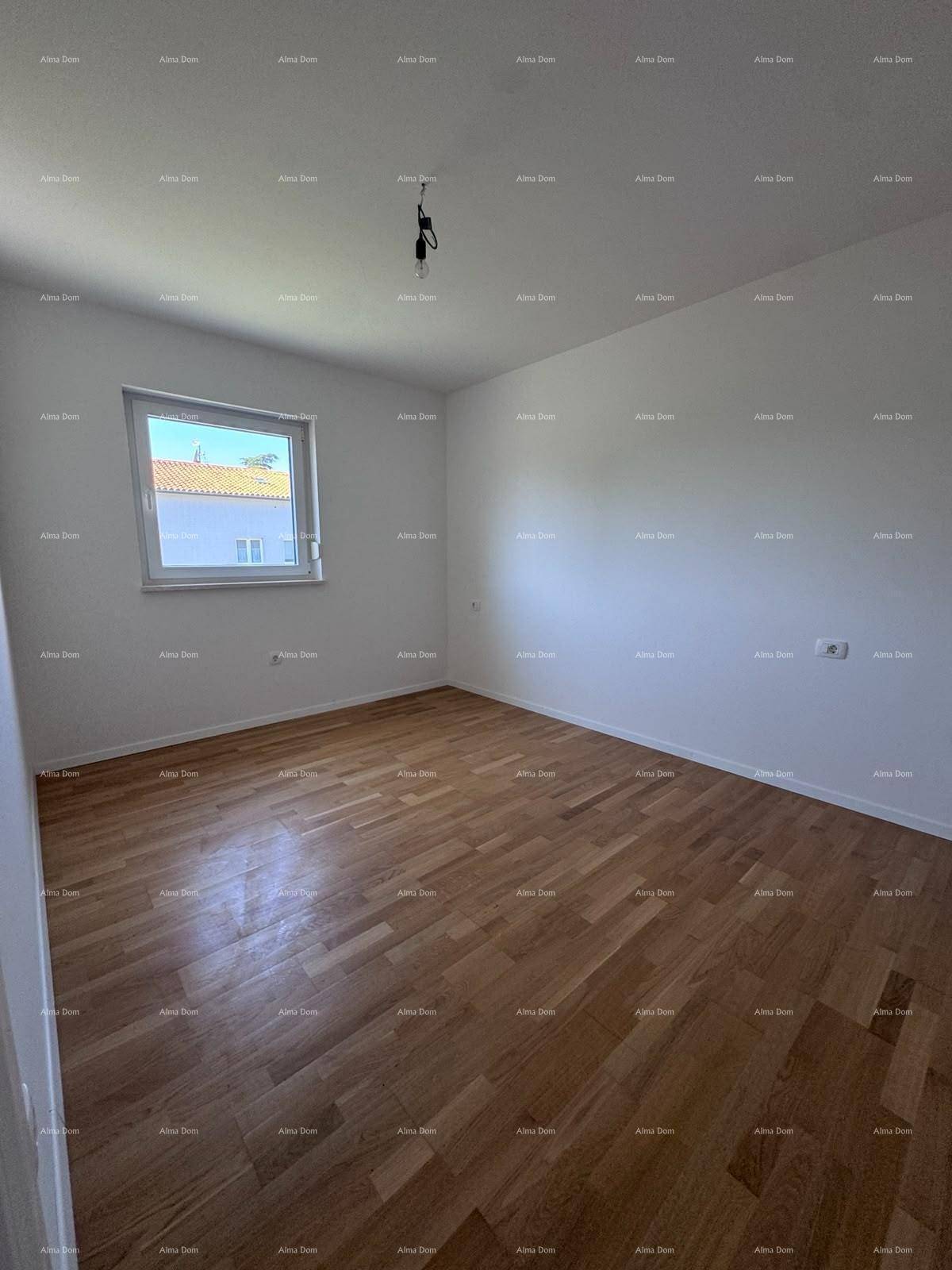 Leeres Schlafzimmer mit warmem Holzparkettboden und einem Fenster für natürliches Licht.