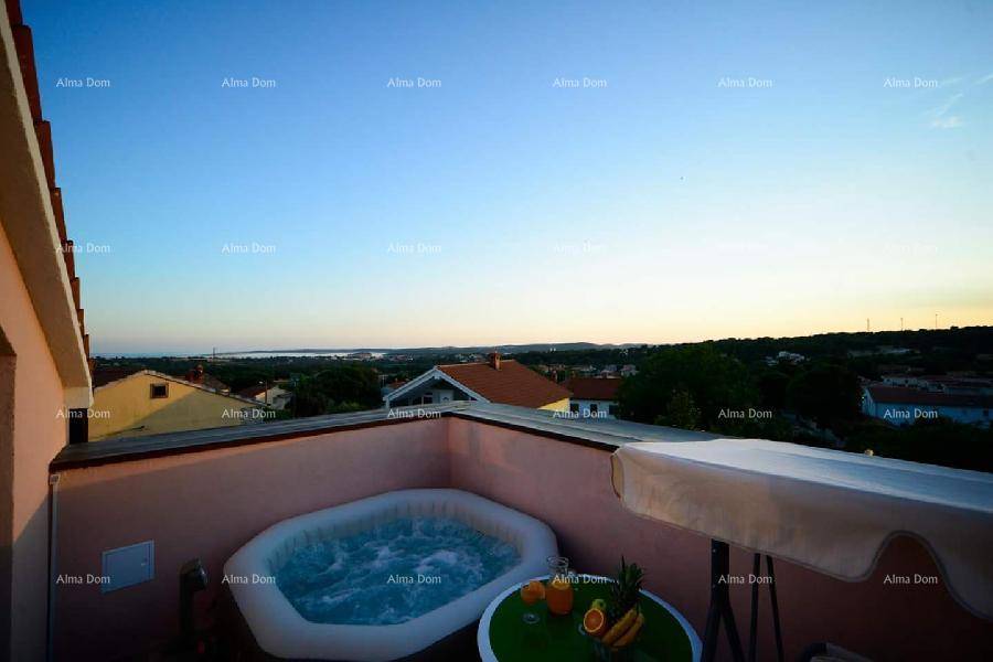 Dachterrasse mit Whirlpool und weitem Blick über die Landschaft bei Sonnenuntergang.