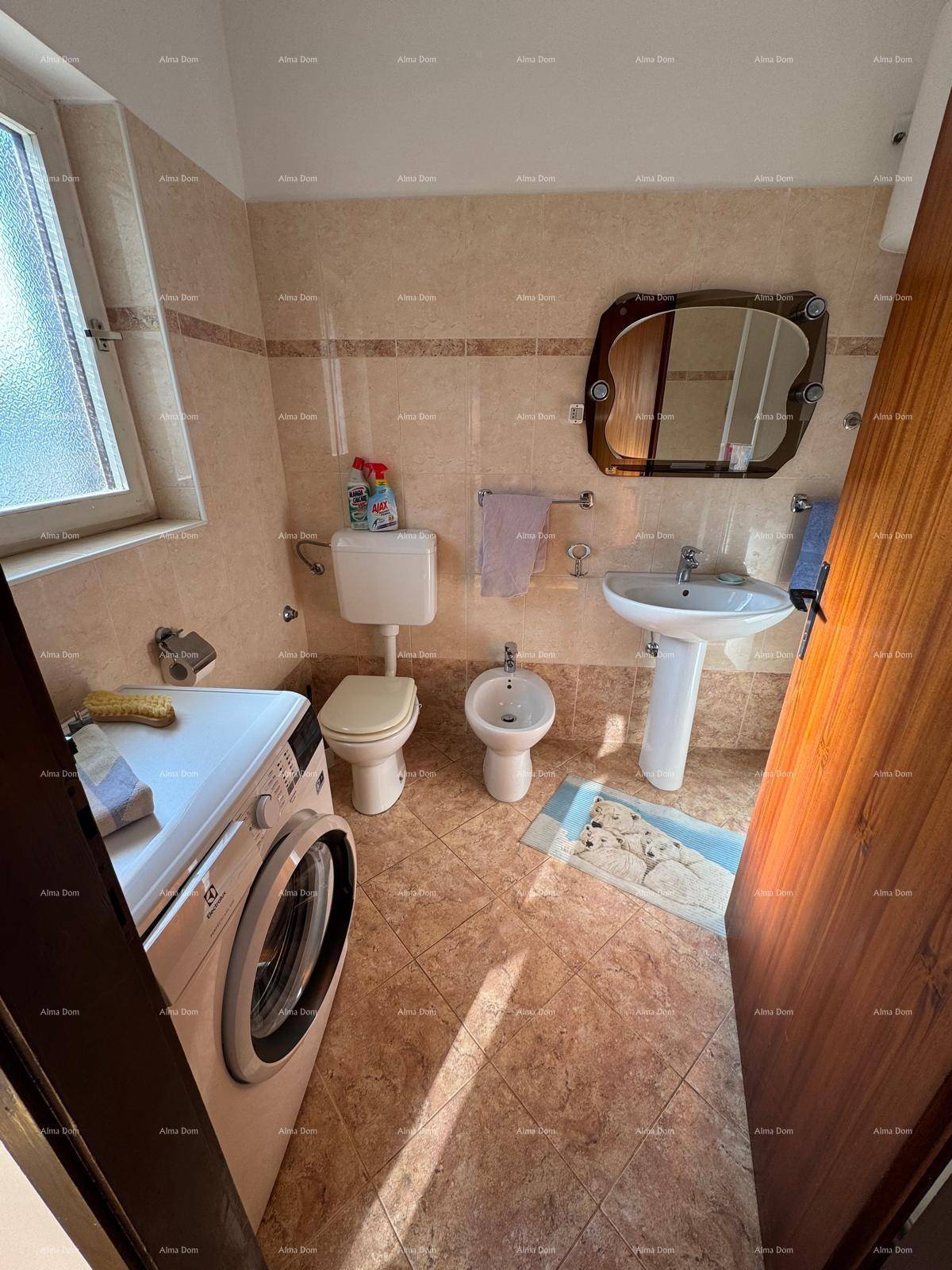 Badezimmer mit Waschmaschine, Toilette, Bidet und Waschbecken, hell gefliest.