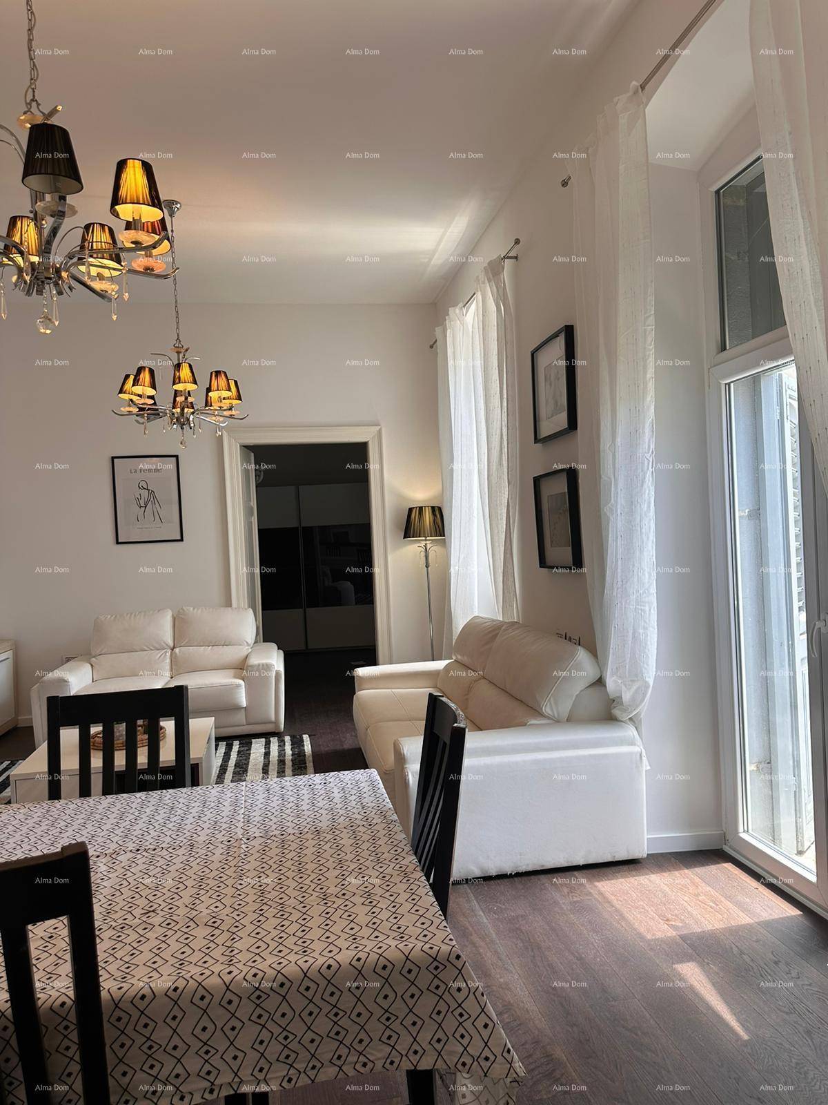 Heller Wohn- und Essbereich mit weißen Sofas, dunklem Holzboden und Zugang zu einem Balkon.