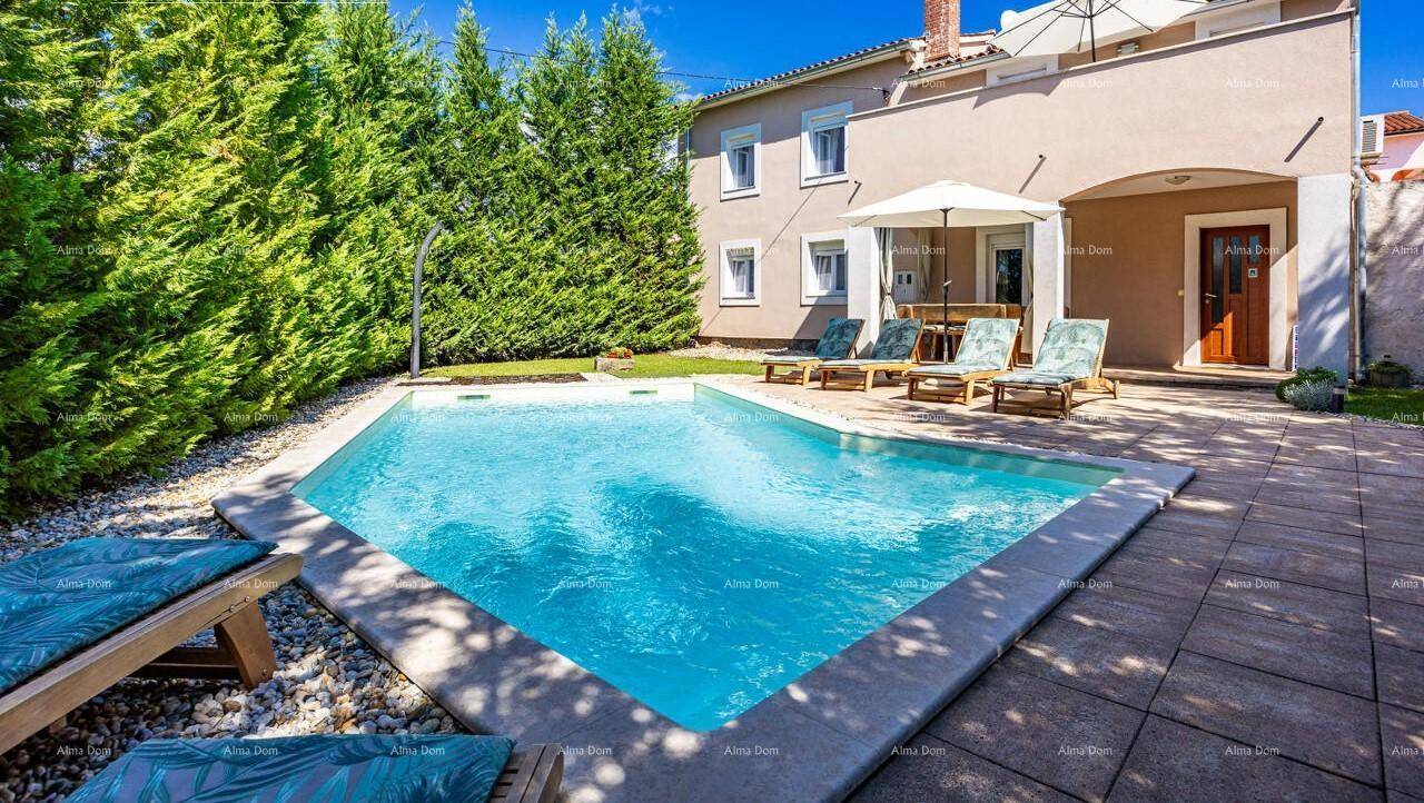 Weitläufiger Außenbereich mit großem Pool, gepflasterter Terrasse und Zugang zum Haus.