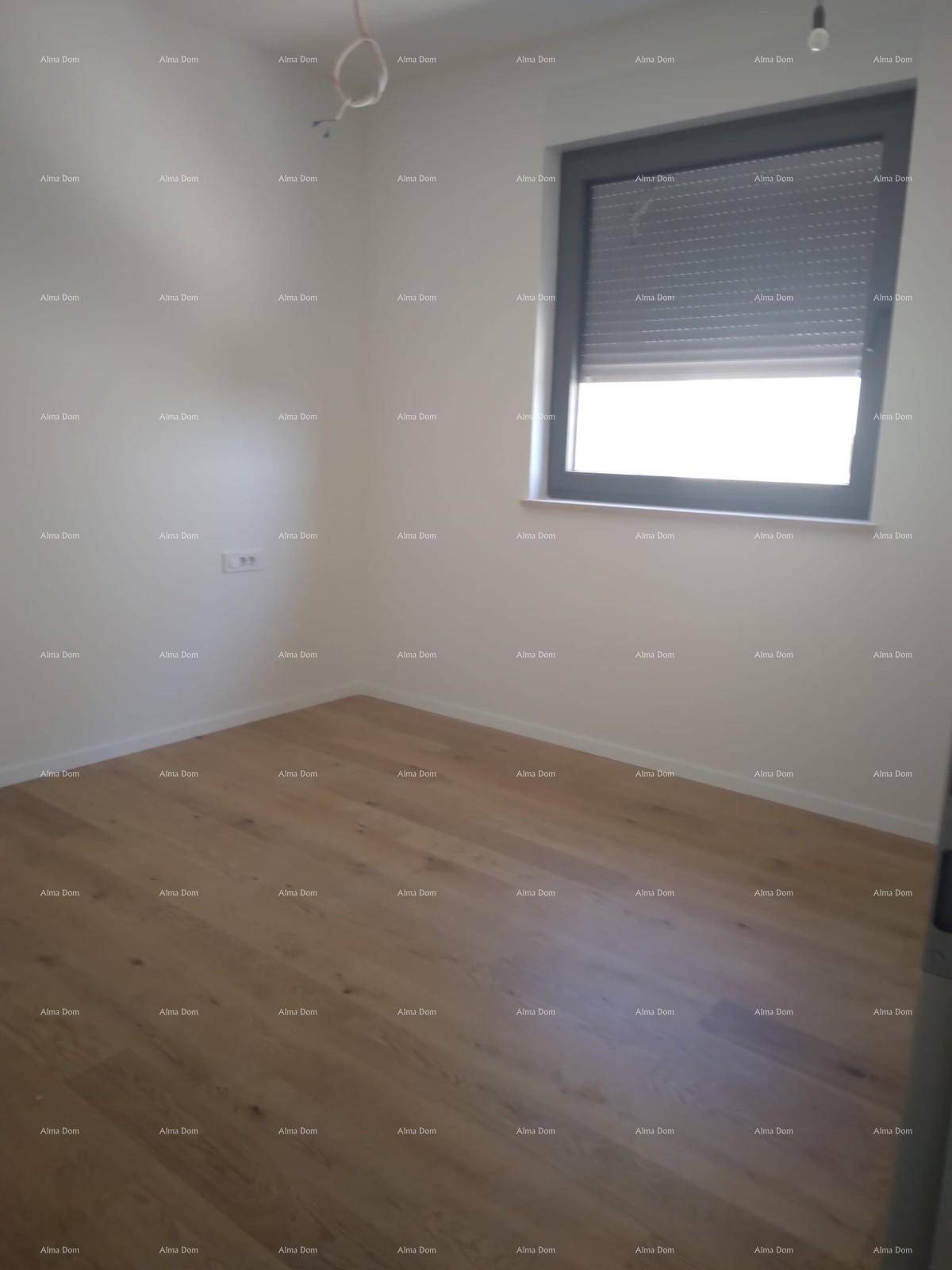 Unmöbliertes Schlafzimmer mit hellem Holzparkett und einem Fenster mit Außenjalousie.