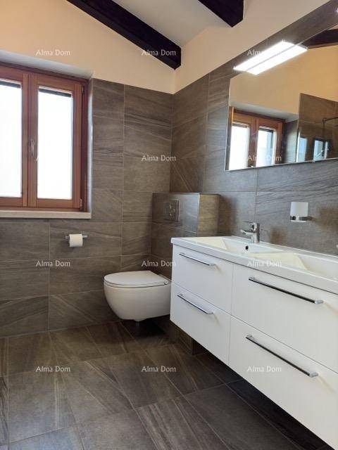Modernes Badezimmer mit dunklen Fliesen, schwebendem Waschtisch und wandhängendem WC.