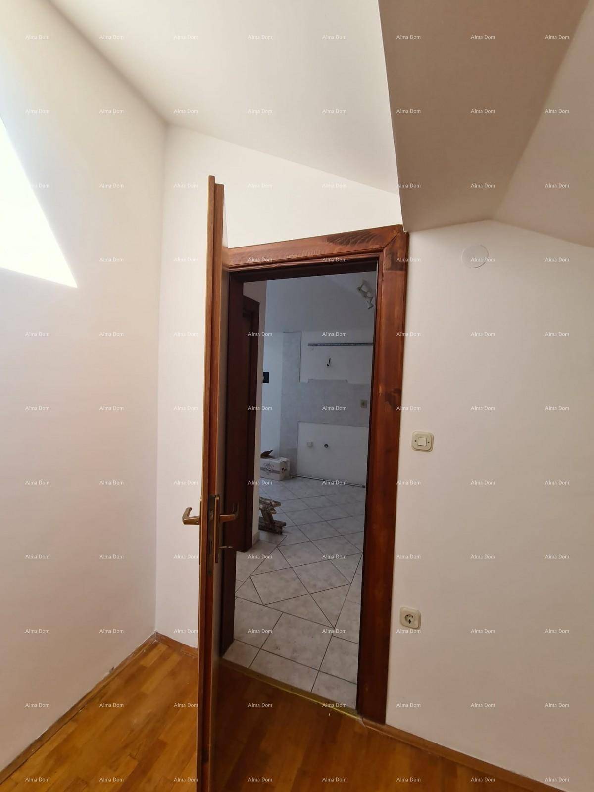 Blick von einem Zimmer mit Holzparkettboden durch eine Tür in einen unfertigen Küchenbereich.