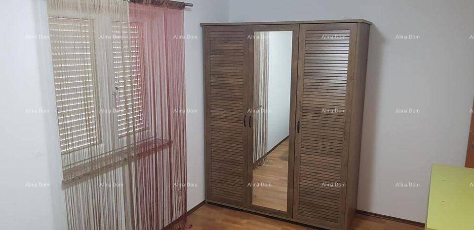 Schlafzimmer mit großem Holzschrank und integriertem Spiegel sowie Fenster mit Jalousien.