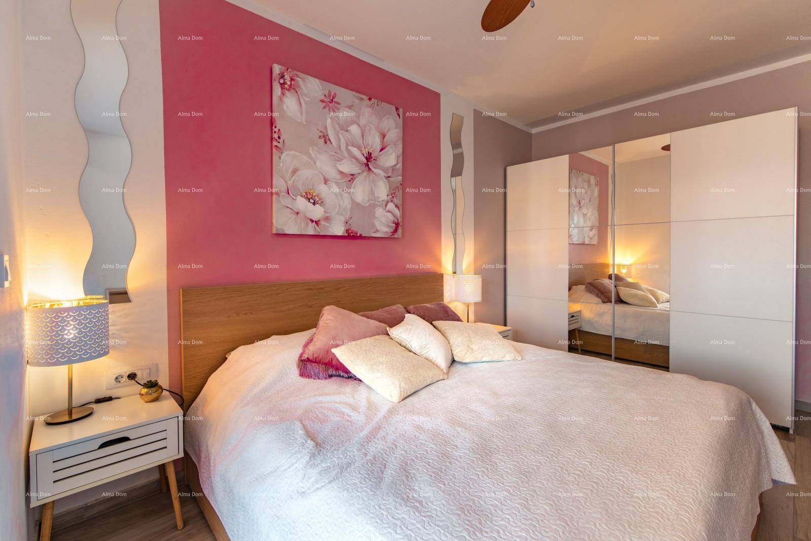 Gemütliches Schlafzimmer mit rosa Akzentwand, Doppelbett und Spiegelschrank.