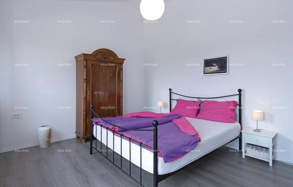 Schlafzimmer mit Doppelbett, Holzkleiderschrank und modernem Laminatboden.
