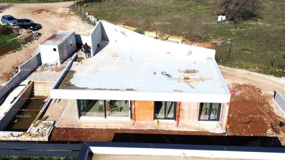 Luftaufnahme der Baustelle einer modernen Villa mit Flachdach und Poolbereich im Rohbau.