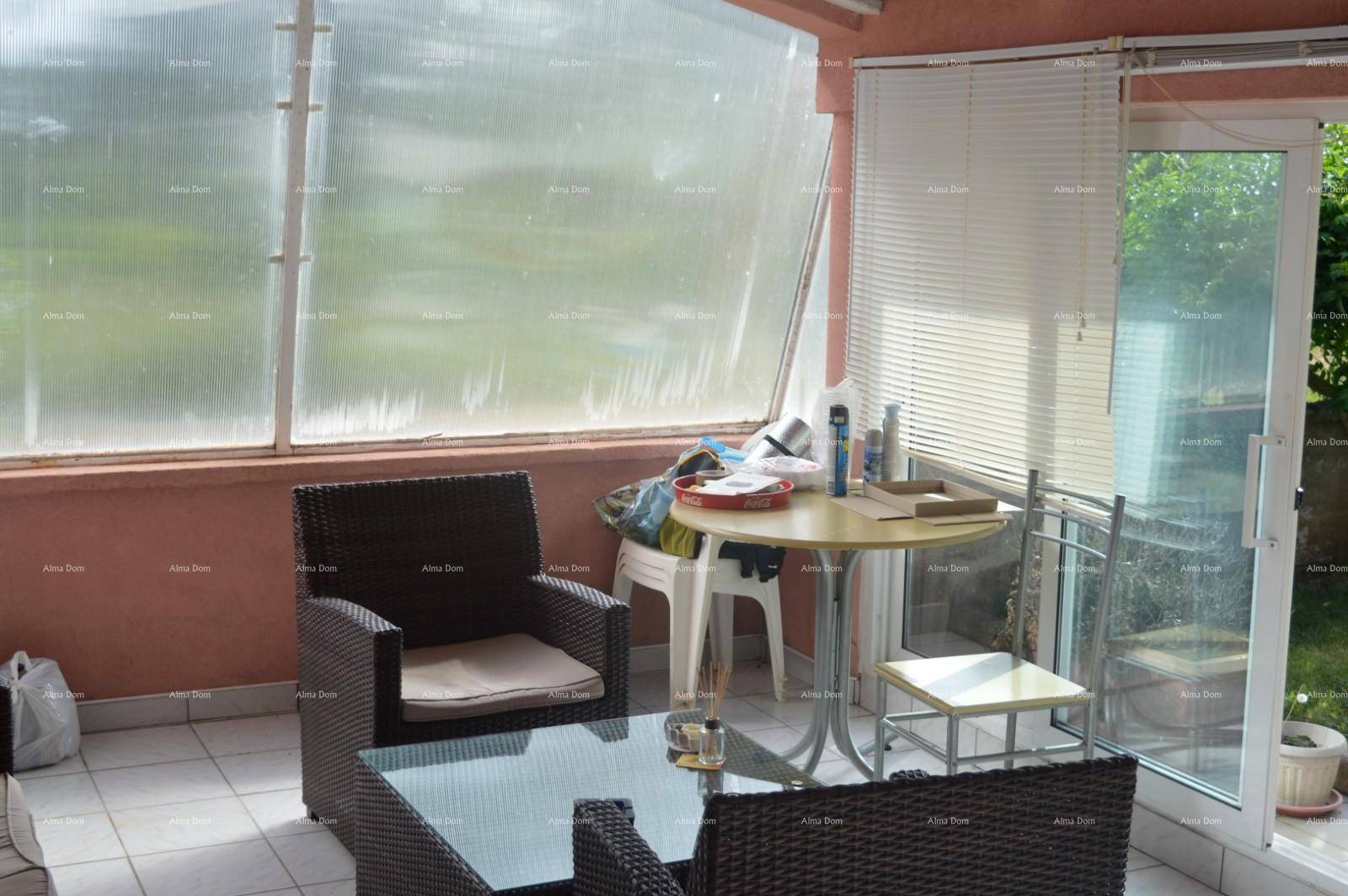 Heller Wintergarten mit kleinem Tisch und Stühlen, ideal für entspannte Stunden.