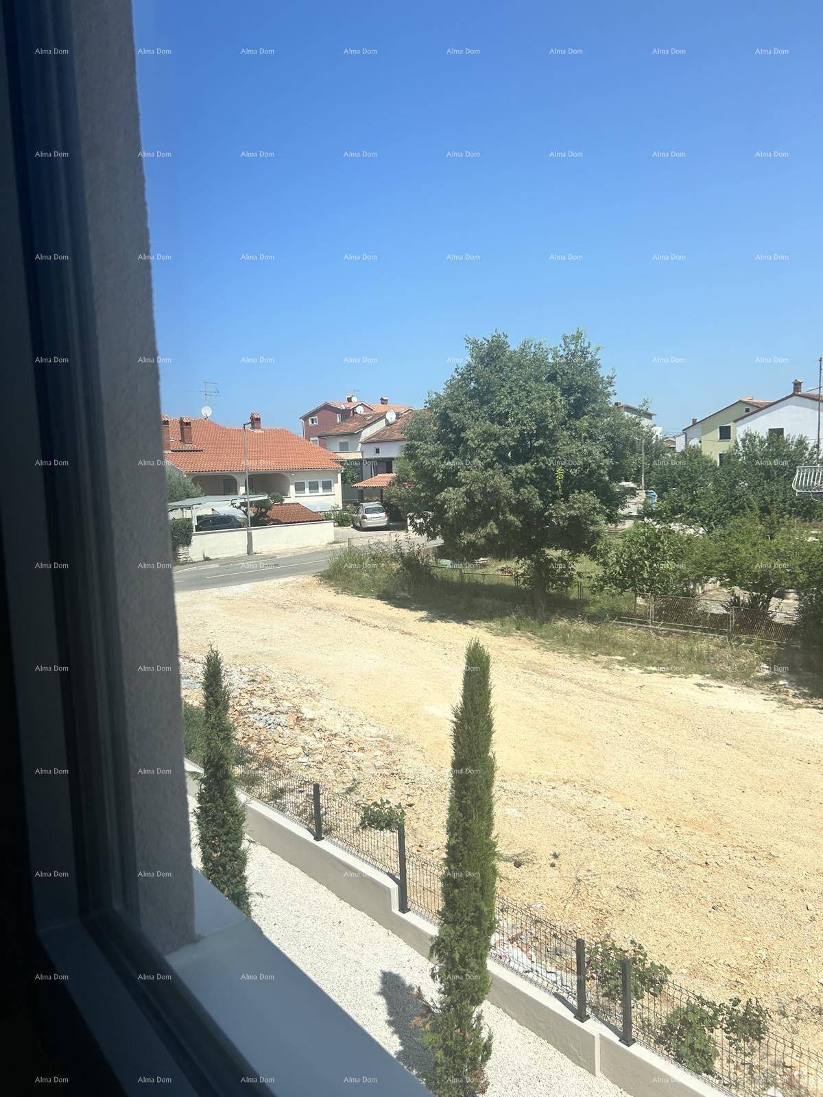 Blick aus dem Fenster auf eine ländliche Umgebung mit Häusern und viel Grün.