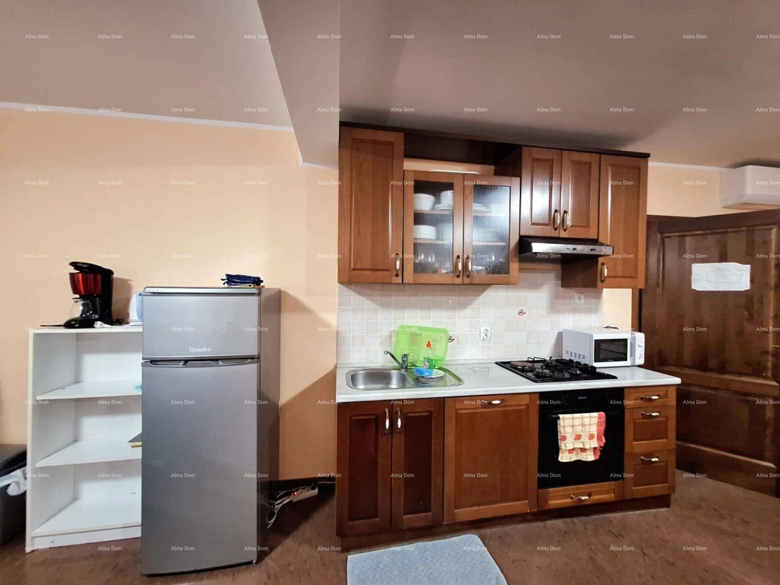 Funktionale Küche mit Holzschränken, Kühlschrank und Kochfeld für den täglichen Gebrauch.