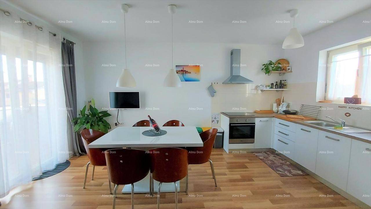 Helle, moderne Küche mit Essbereich, Holzboden und Zugang zu einem Balkon oder einer Terrasse.