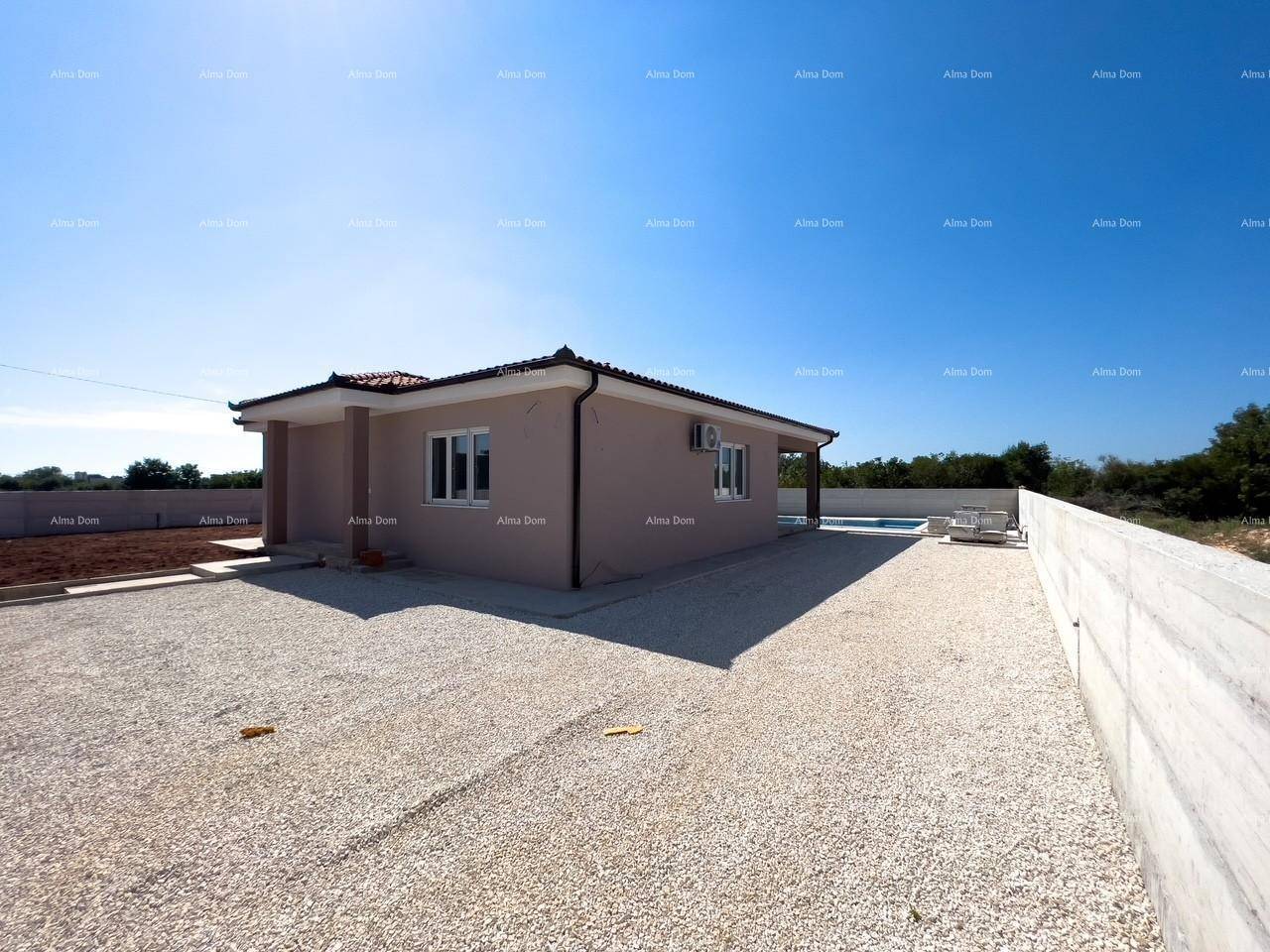 Freistehendes Einfamilienhaus mit beiger Fassade, Kiesfläche und Poolbereich im Hintergrund.
