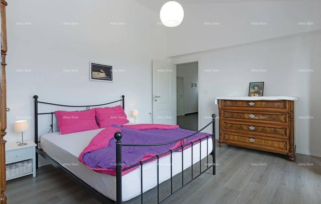 Helles Schlafzimmer mit Doppelbett, antiker Kommode und Laminatboden.
