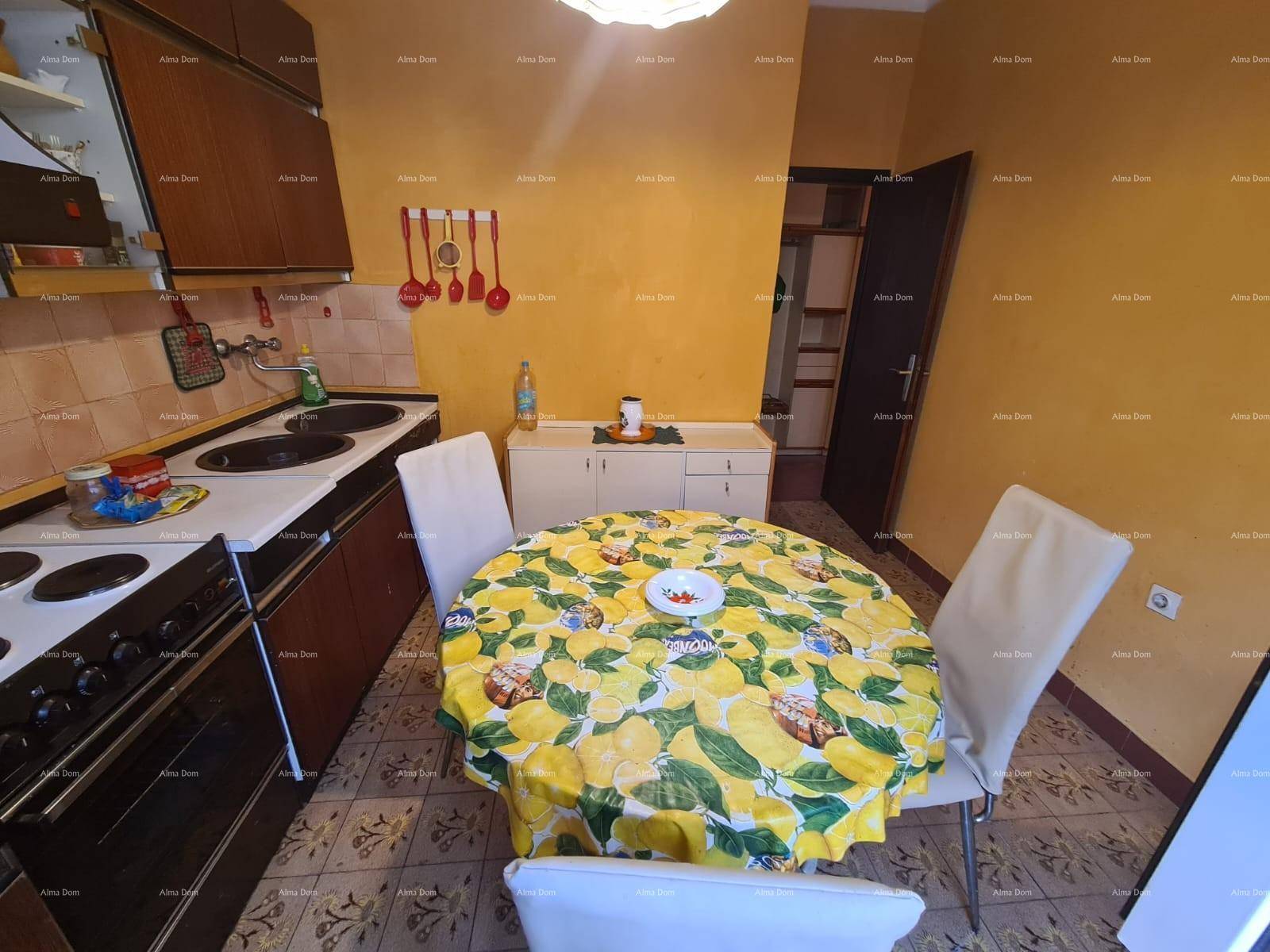 Küche mit Essbereich, gelben Wänden, dunklen Holzschränken und einem runden Esstisch.