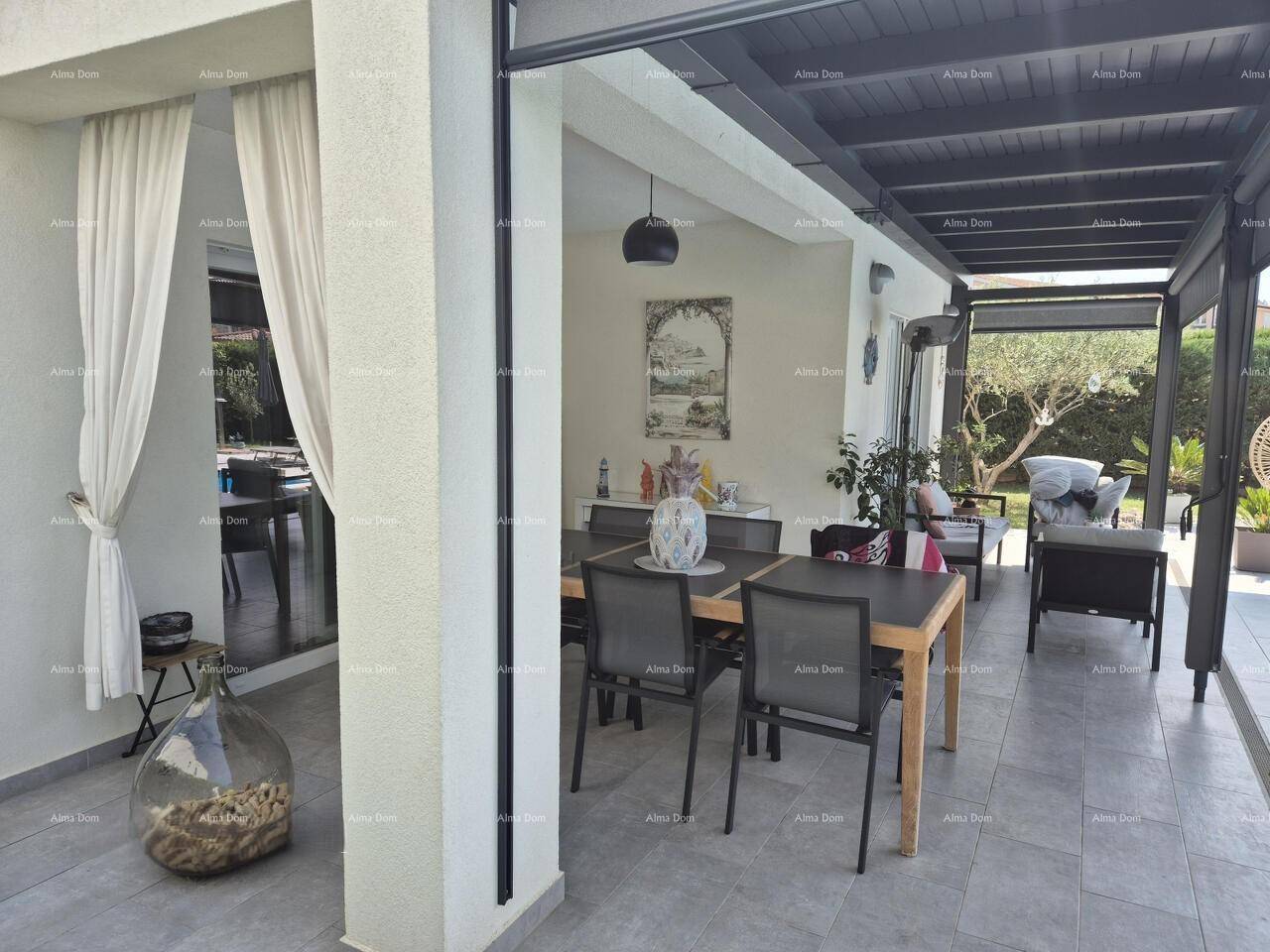 Überdachte Terrasse mit großem Esstisch und Lounge-Möbeln, ideal für Mahlzeiten im Freien.