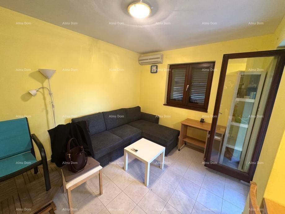 Gemütliches Wohnzimmer mit gelben Wänden, Sofa, Fliesenboden und Zugang zur Terrasse.