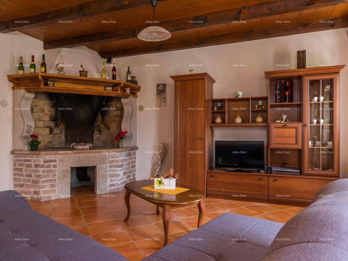 Wohnzimmer mit traditionellem Kamin, Holzbalkendecke und rustikalen Möbeln.