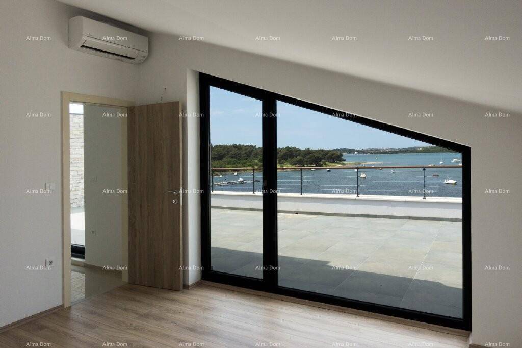 Heller Raum mit großer Fensterfront, Klimaanlage und Blick auf die Terrasse und das Meer.