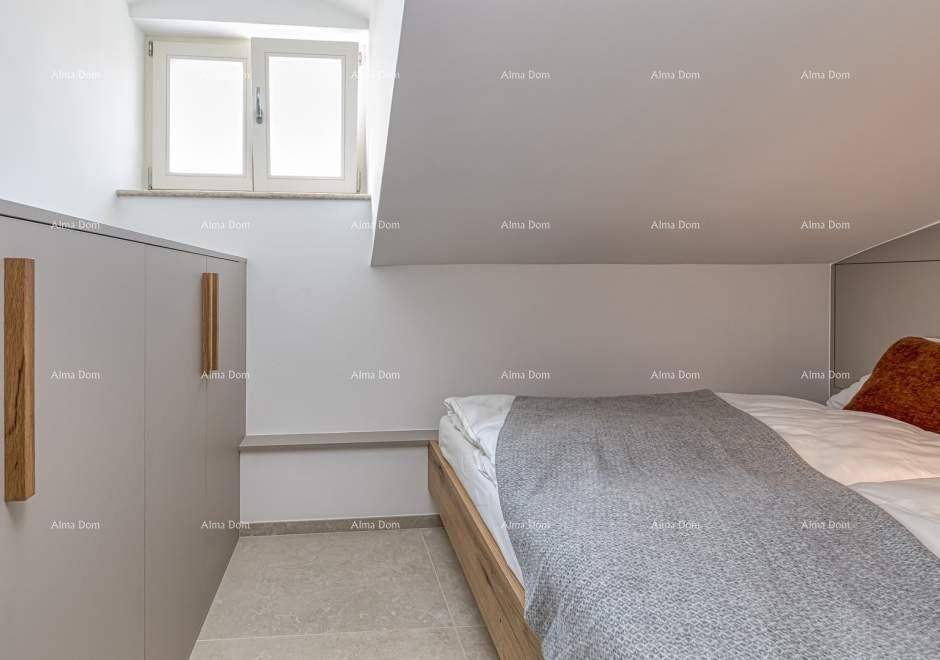 Helles Schlafzimmer im Dachgeschoss mit Doppelbett, Einbauschränken und Fenster in der Dachschräge.