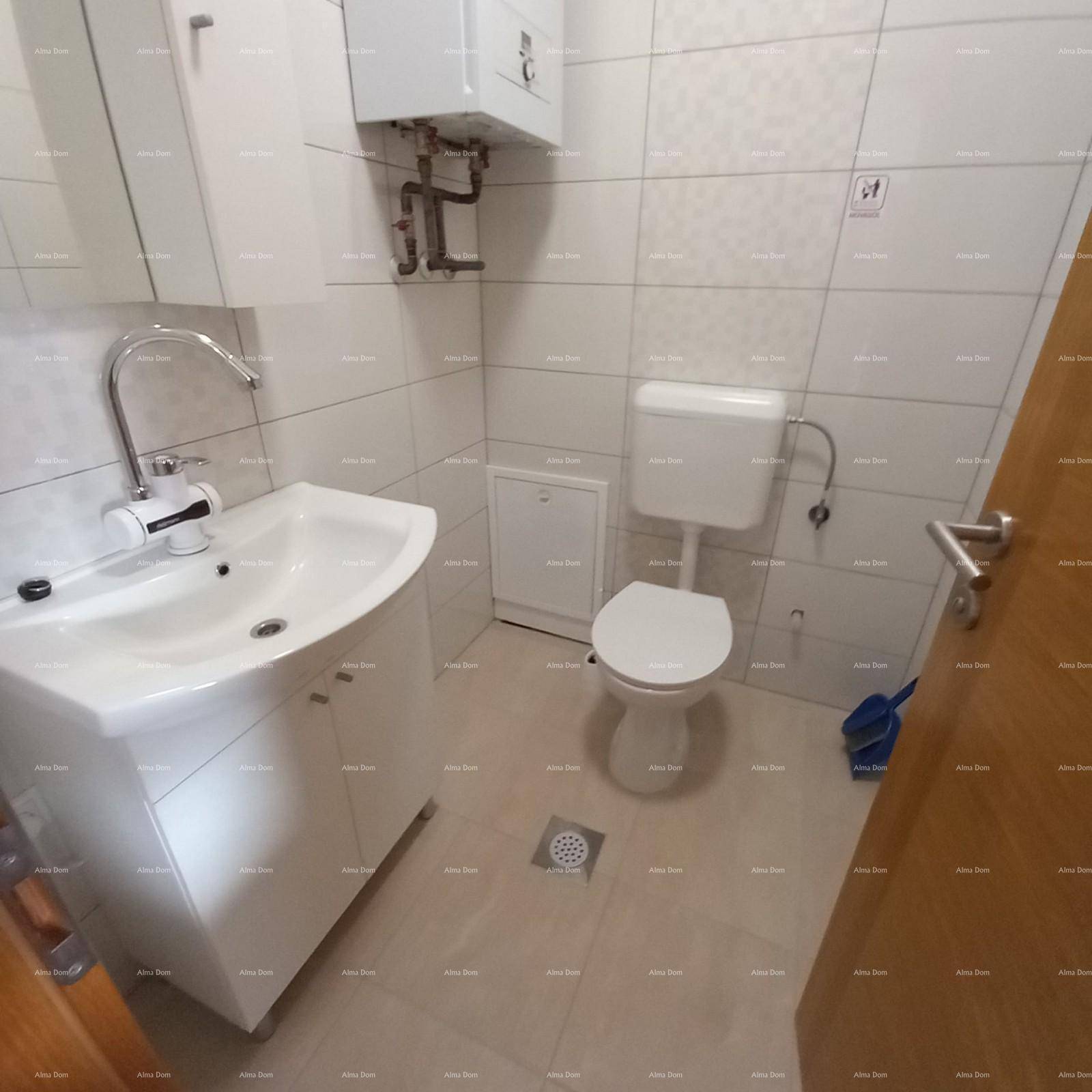 Funktionales WC mit weißen Fliesen, modernem Waschbecken und Toilette, sauber und hell.