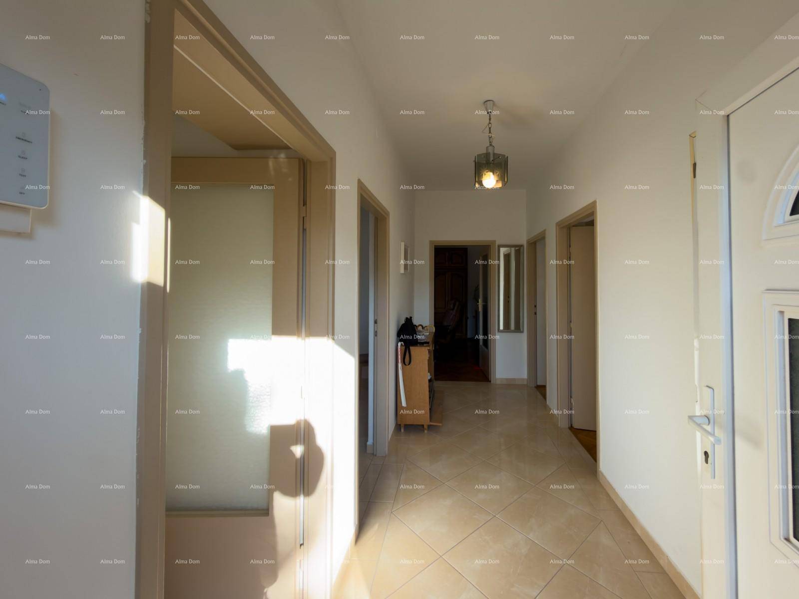 Heller Flur mit Fliesenboden und mehreren Türen, durchflutet von Sonnenlicht.