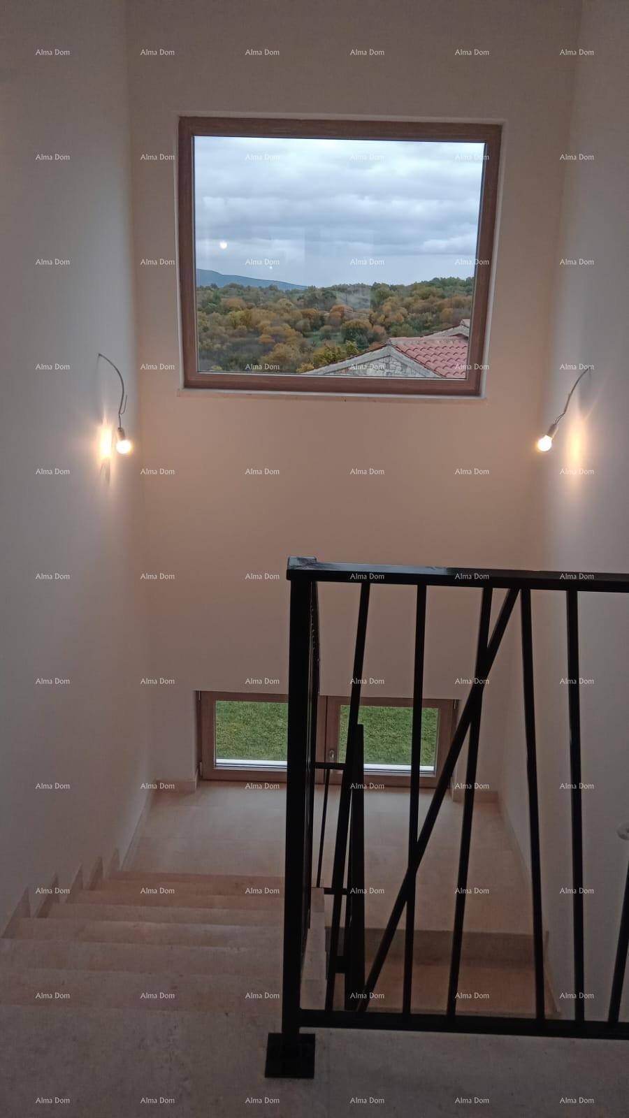 Heller Treppenaufgang mit großem Fenster und Blick auf die umliegende Landschaft und Bäume.