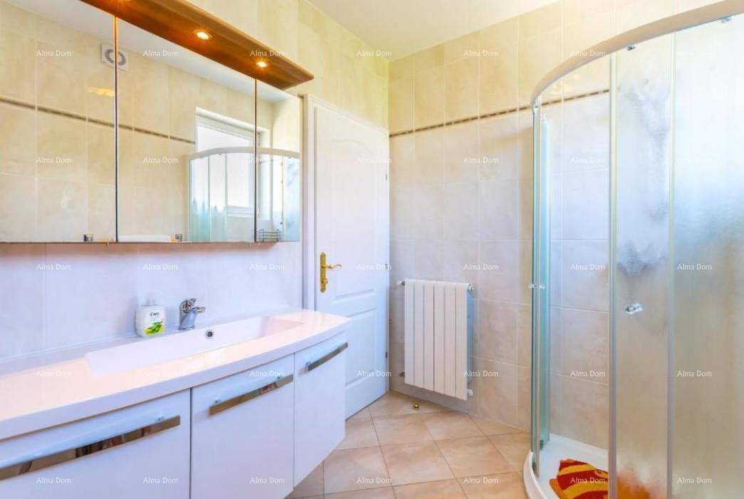 Modernes Badezimmer mit Duschkabine, Einzelwaschbecken und hellen Fliesen.