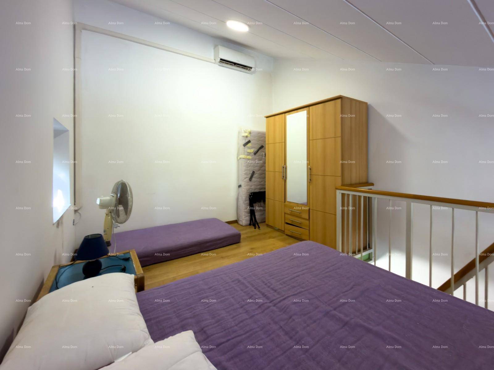 Helles Schlafzimmer auf der oberen Ebene mit Holzboden und Klimaanlage.