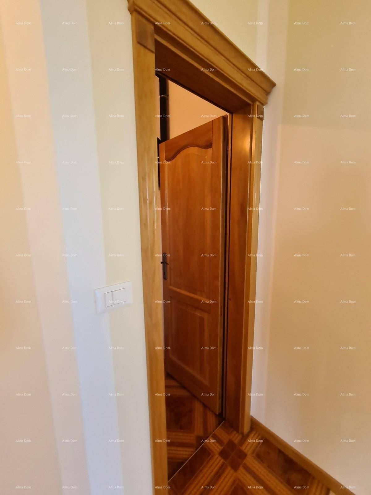 Holztür in einem hellen Flur mit gemustertem Parkettboden.