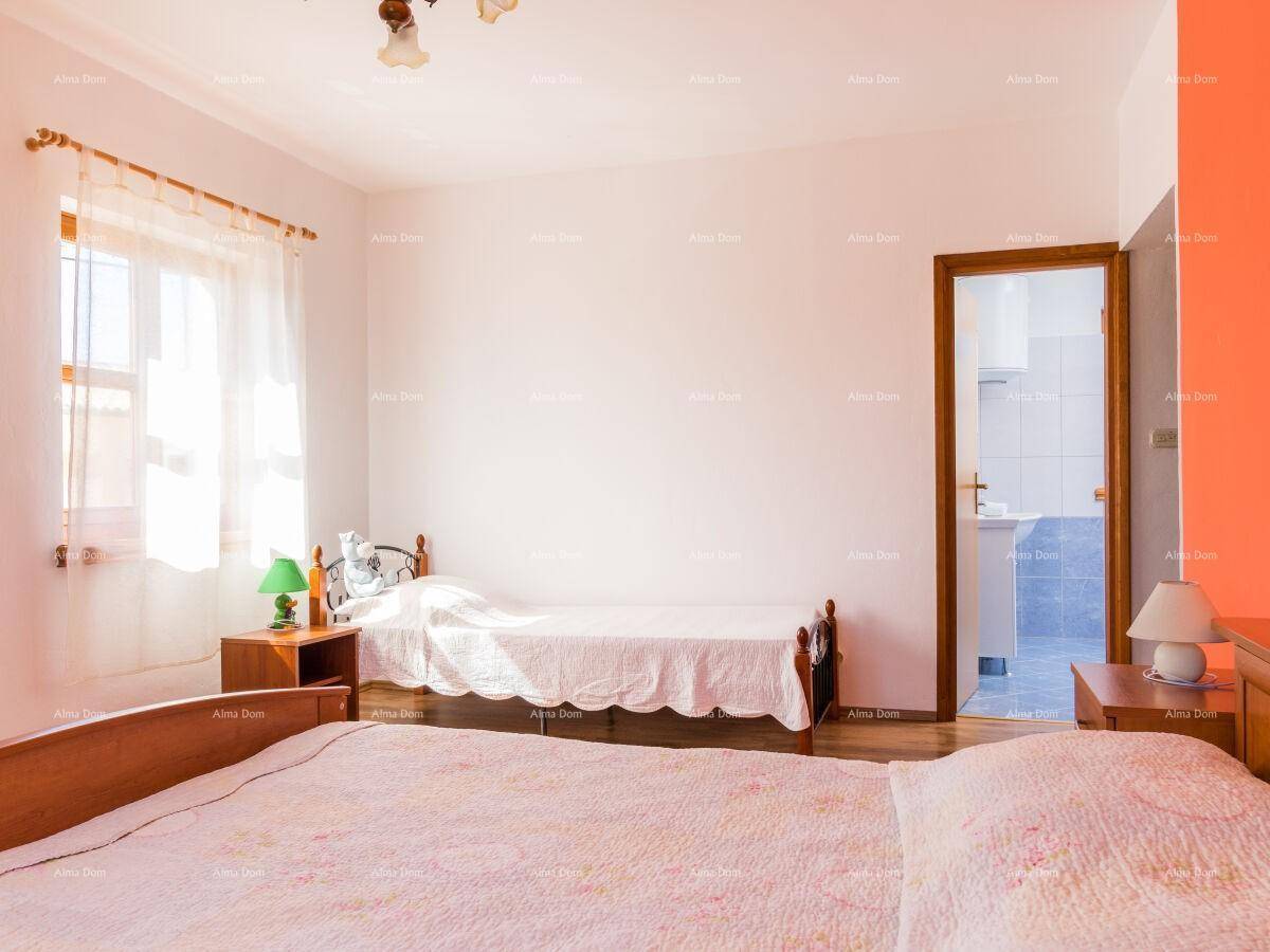 Helles Schlafzimmer mit Holzboden und Zugang zu einem angrenzenden Badezimmer.