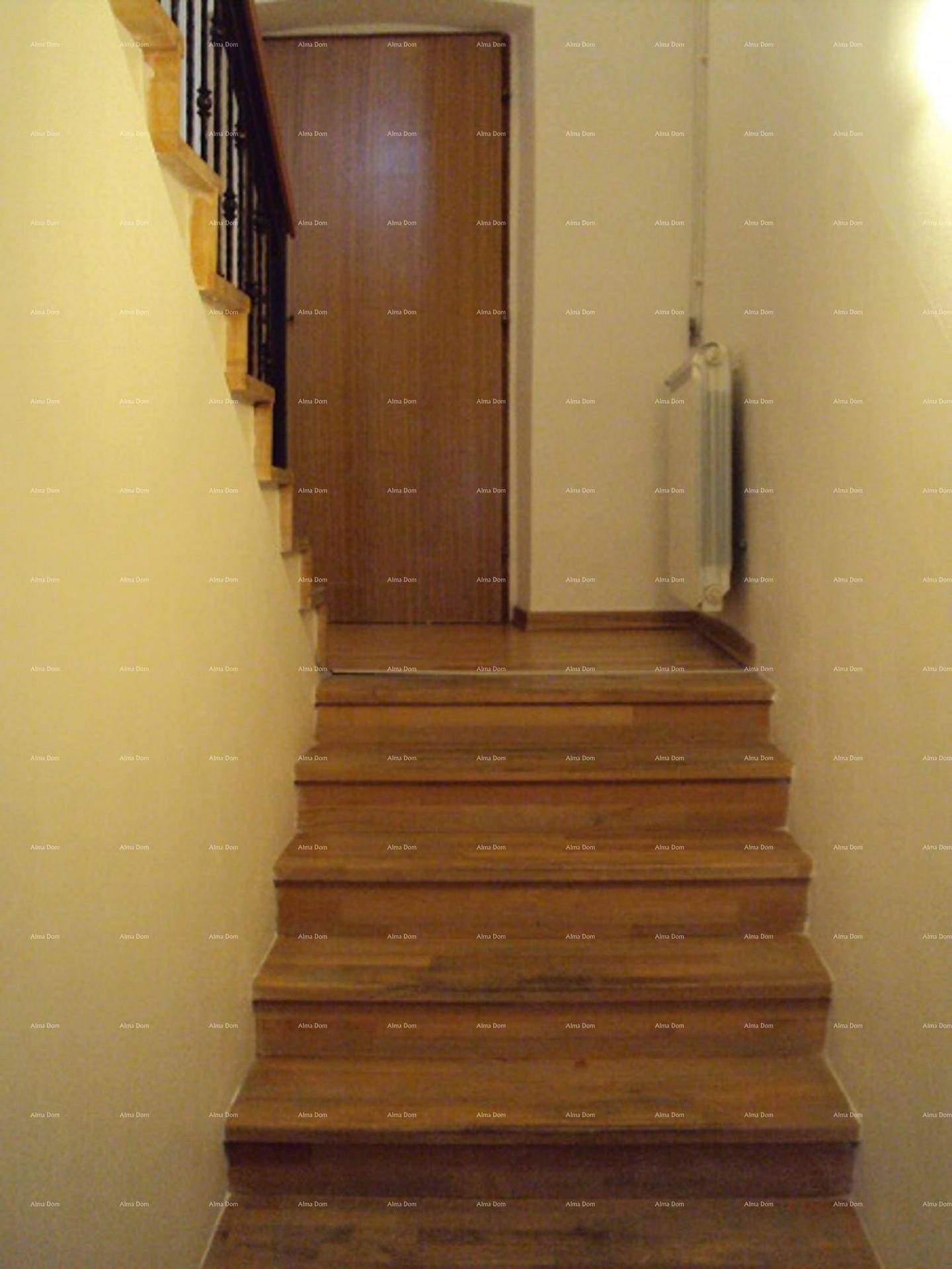 Holztreppe mit Geländer und einem Heizkörper an der Wand.