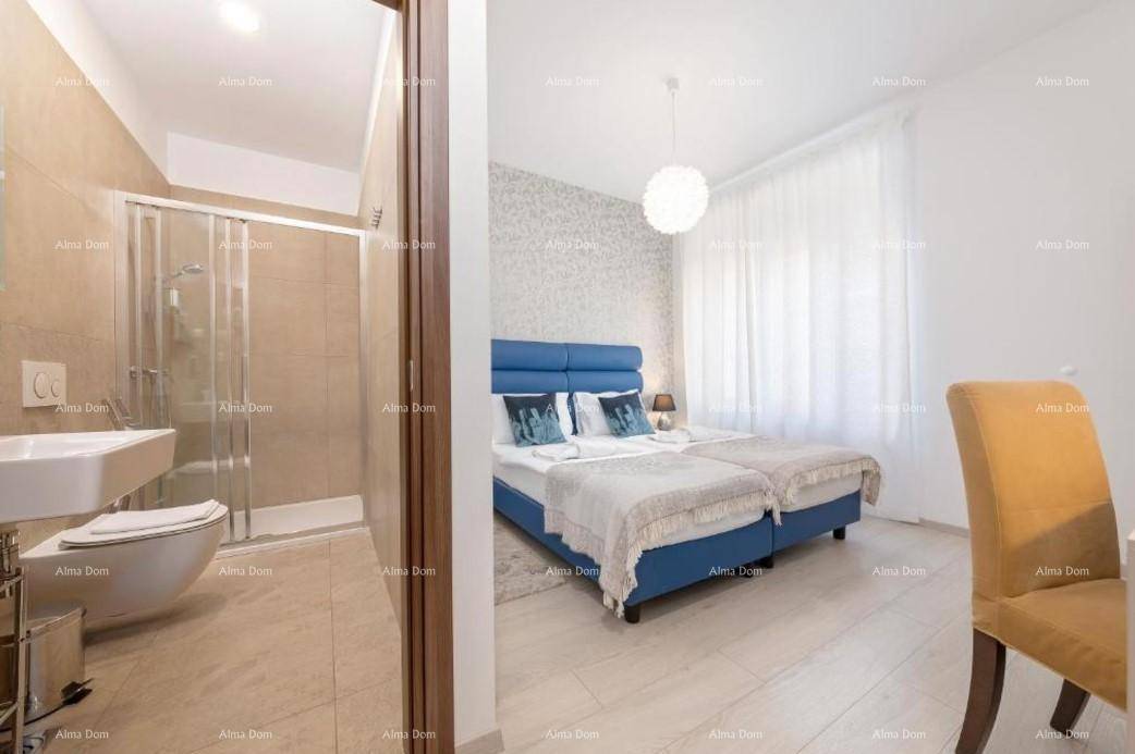 Schlafzimmer mit Zugang zu einem modernen Badezimmer, ausgestattet mit Dusche, WC und Waschbecken.