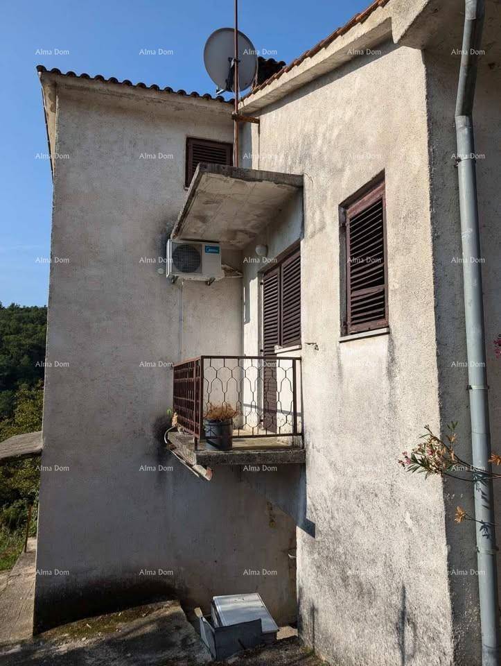 Fassade des Gebäudes mit einem kleinen Balkon, Metallgeländer und einer Klimaanlage.