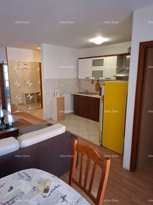 Offener Wohn- und Essbereich mit integrierter Küche und Holzboden, ideal für geselliges Beisammensein.