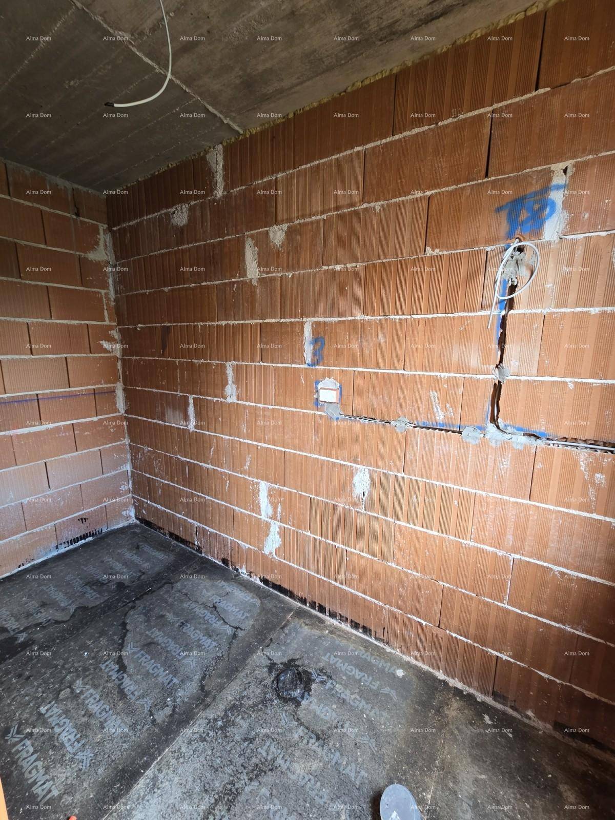 Ecke eines Raumes im Rohbau mit Ziegelwänden und vorbereiteten Elektroinstallationen.