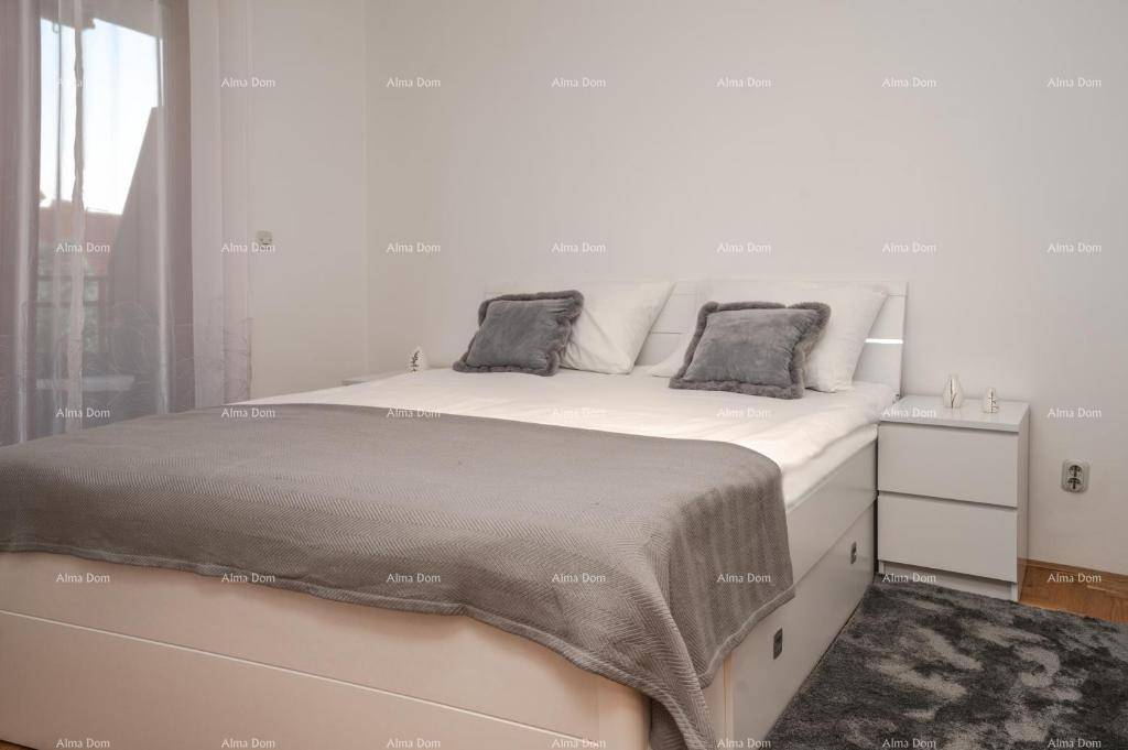 Helles Schlafzimmer mit einem modernen weißen Bett, grauer Bettwäsche und einem Nachttisch.