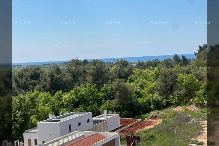 Ausblick auf die umliegende Natur, weitere Gebäude und das glitzernde Meer am Horizont.